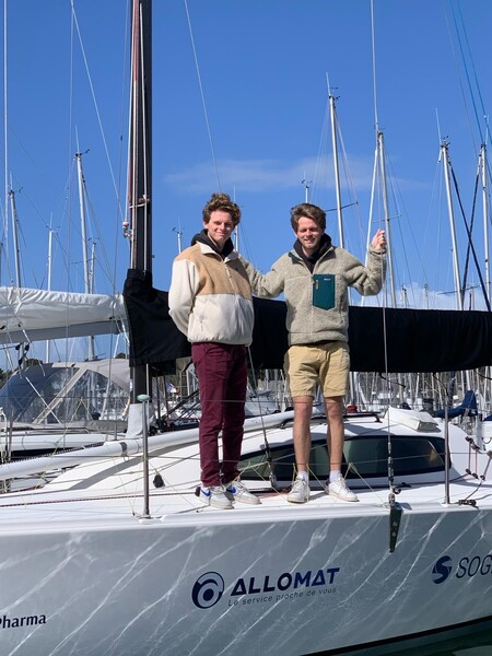 Victor et Oscar Gerin, sur un voilier, avec le logo d'Allomat sur la coque.