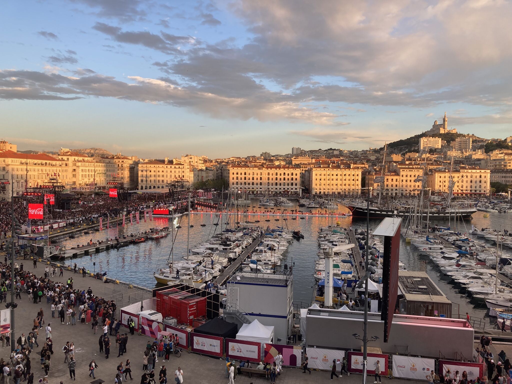 Une vue du Vieux-Port de Marseille avec une construction modulaire Allomat au 1er plan, le navire Le Belem au milieu du Vieux-Port et Notre-Dame-de-la-Garde en fond.