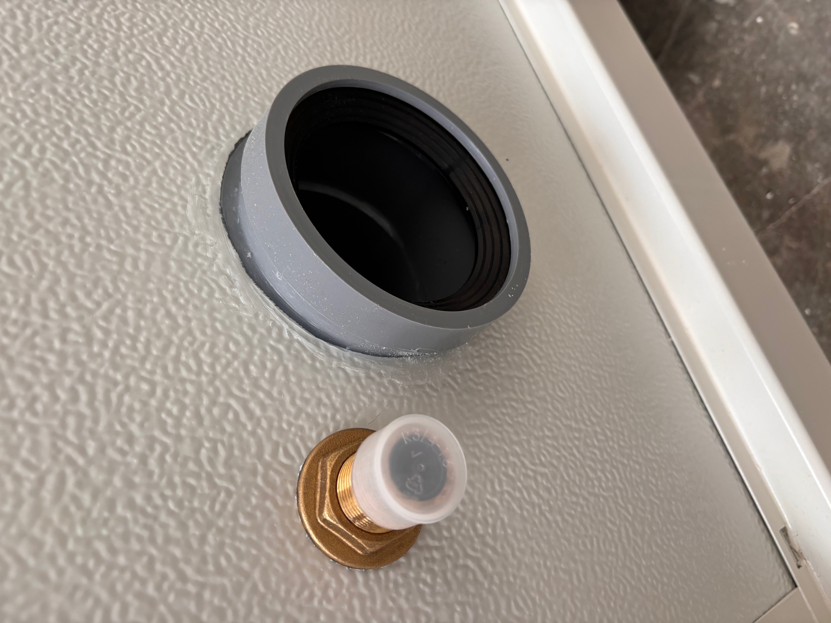 Un module Sanibox d'Allomat, module sanitaire avec un toilette, un lavabo, un panneau électrique en haut à droite et un miroir sur le mur de gauche au-dessus du lavabo.