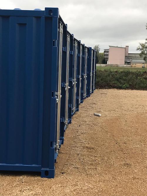 Alignement de conteneurs de stockage bleus en location, vus de côté.