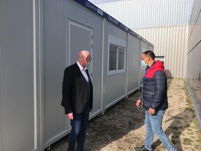 Deux hommes discutant devant des modules Allomat en location.