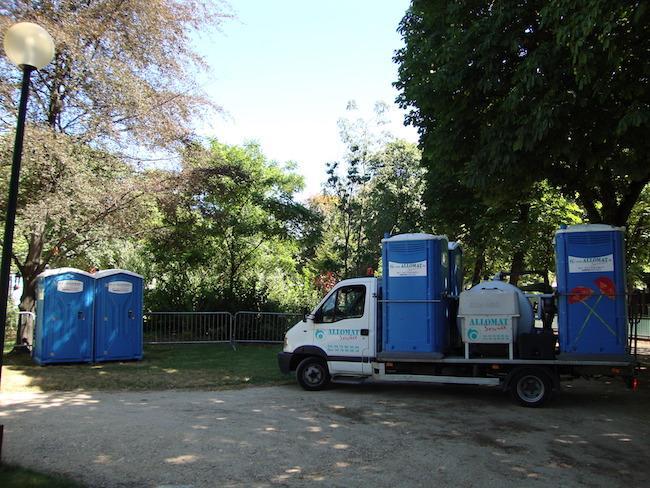 Camion de service Allomat pour la maintenance des toilettes portables installées dans un parc.