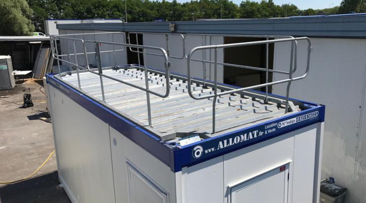 Toit d'une baraque de chantier modulaire Allomat avec balustrade de sécurité.