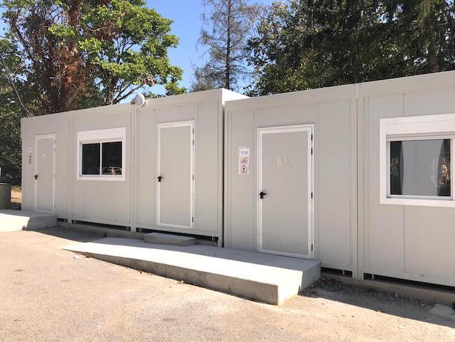 Façade de modules de salle de classe préfabriquée avec fenêtres et rampes d'accès.