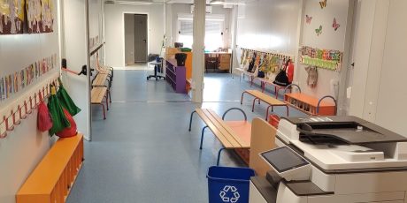 Intérieur d’une salle de classe modulaire avec tables, chaises et aménagement adapté à un espace scolaire temporaire.