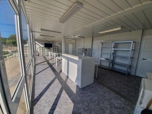 Grand intérieur de module vitré aménagé en bureau d'accueil.