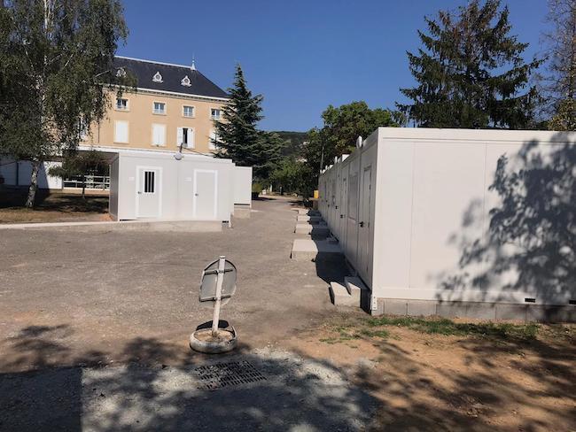 Alignement de modules de salle de classe préfabriquée sur le terrain d'une école existante.