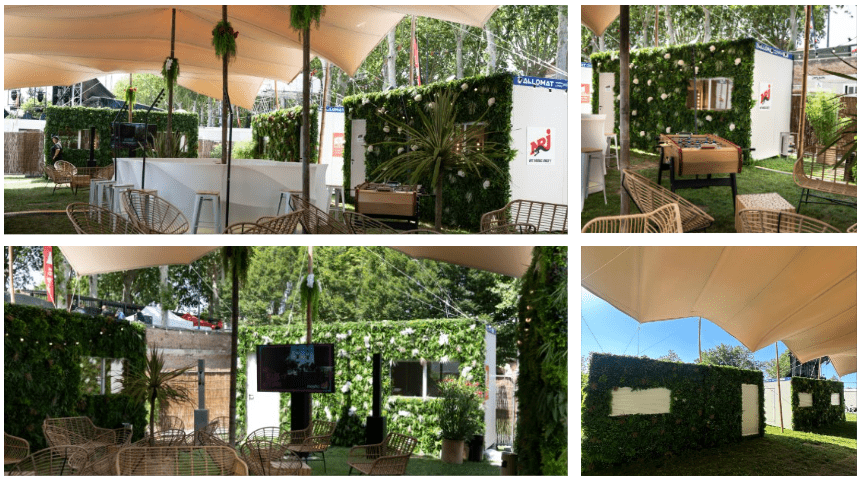 Structure modulaire événementielle conçue par Allomat avec une décoration sur-mesure pour les loges du NRJ Music Tour. Les modules sont aménagés en espace de réception ou de détente, avec des murs extérieurs recouverts de murs végétaux pour une esthétique naturelle. L'espace comprend des zones ombragées par des toiles tendues, du mobilier en rotin, un bar, un baby-foot et des écrans. Ces structures modulaires démontrent un haut niveau de personnalisation pour l'événementiel.